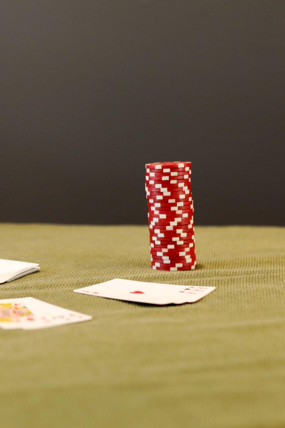 Chip poker merah tersusun di atas meja hijau